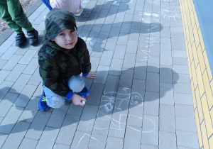 Oskarek maluje Dinka na chodniku